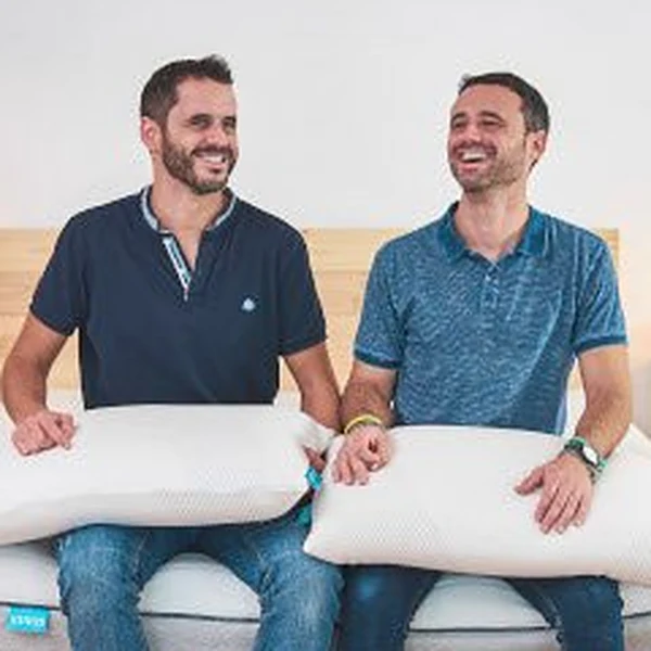 Manel y Albert, fundadores de Lektulos, sentados en un colchón Lektulos